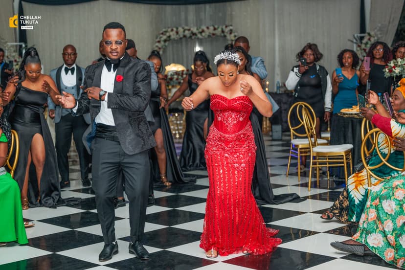 Couple dancing at reception - bride in red sequined gown, groom in black tuxedo
