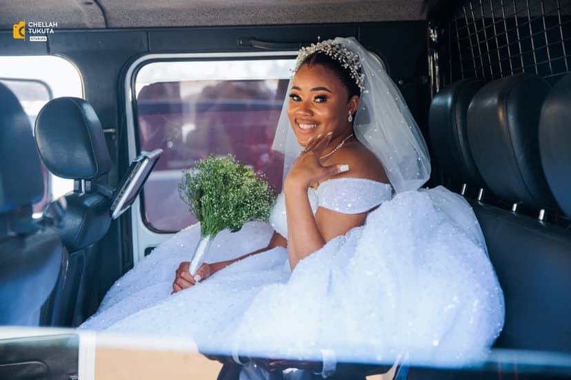 Bride in luxury car wearing sparkly white ball gown with tiara and bouquet