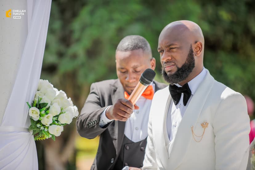 Groom speaking into microphone during outdoor garden ceremony