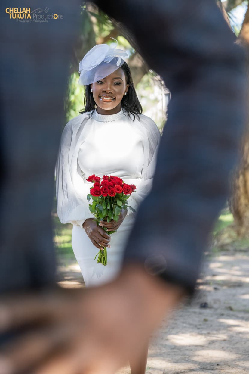 Artistic bridal portrait with red roses framed by trees